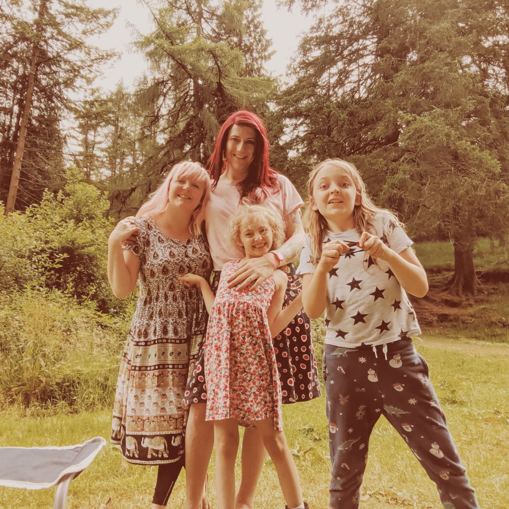 two women and two children smiling on a camping trip